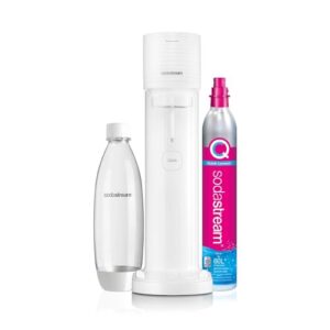 Un gasatore di acqua gassata di colore bianco è posizionato su un piano di lavoro chiaro. Accanto, ci sono bottiglie d'acqua e un bicchiere, creando un ambiente domestico accogliente.